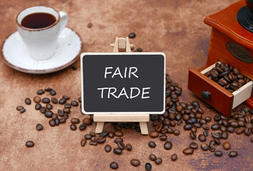 Kaffeemühle mit einer Tasse Kaffee und Label mit der Inschrift Fair Trade. - obrazy, fototapety, plakaty