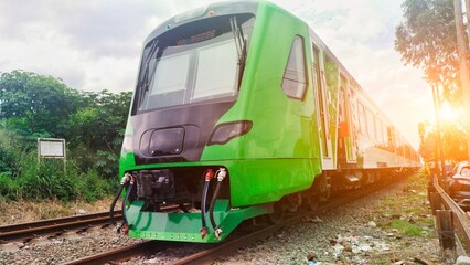 Feeder trains run on the tracks. This green train is operated to connect Bandung Station and Padalarang Fast Train Station