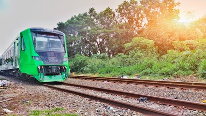 Feeder trains run on the tracks. This green train is operated to connect Bandung Station and...