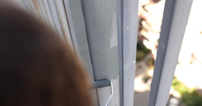 Painting the fence frame by hand with a brush