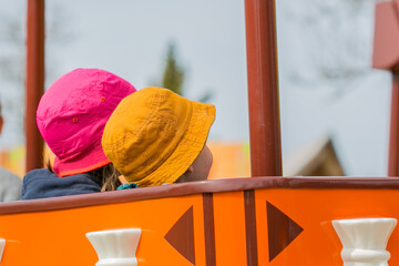 Fund and leisure: two children with colorful hats in carousel