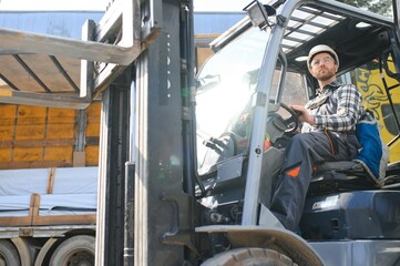 Portrait of heavy industry forklift driver giving thumbs up and smiling