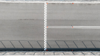Fototapeta premium Aerial view abstract asphalt black Start and Finish grid line for race car in circuit texture background, Automobile and automotive background.