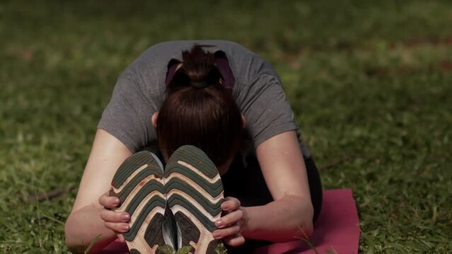Woman Does Seated Pike Stretch in Nature, Slow Motion