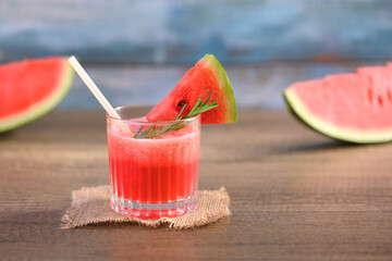 Glass of fresh watermelon juice on wooden table with copy space. Summer drink concept