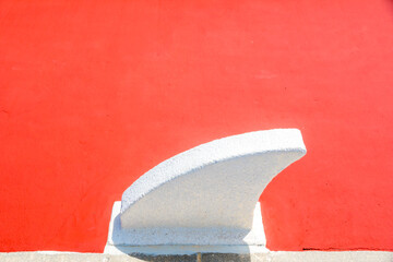 white concrete wave stands out against a vibrant red background
