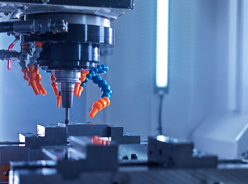 Computerized CNC machine drilling metal object at factory