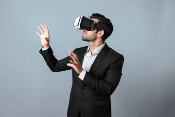 Business man looking data analysis by using VR glasses. Project manager checking business strategy by enter in metaverse or virtual reality world while wearing suit at white background. Deviation.