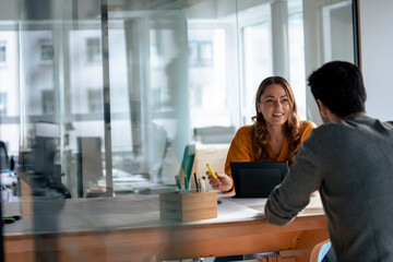 Smiling mature architect discussing with colleague in office