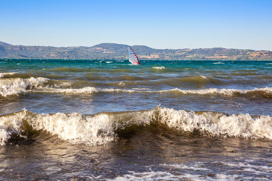 Italy, Lazio, Anguillara Sabazia, Waves on Lake Bracciano with windsurfer in background