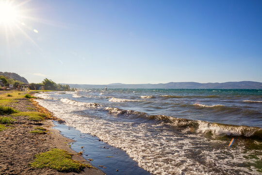 Italy, Lazio, Anguillara Sabazia, Sun shining over shore of Lake Bracciano