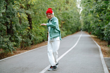 Happy young woman wearing wireless headphones and dancing on road