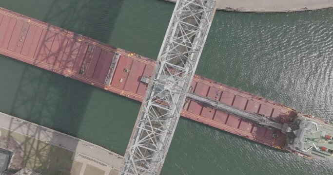 Top Down Aerial of Cargo Ship Passing Under Aerial Lift Bridge in Duluth, Minnesota