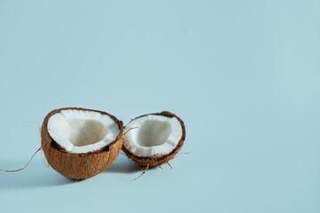 Broken coconut pieces on a blue background. - 791416827