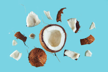 Broken coconut pieces on a blue background. - 791416843