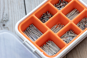 Collection of nails, screws and bolts in plastic box