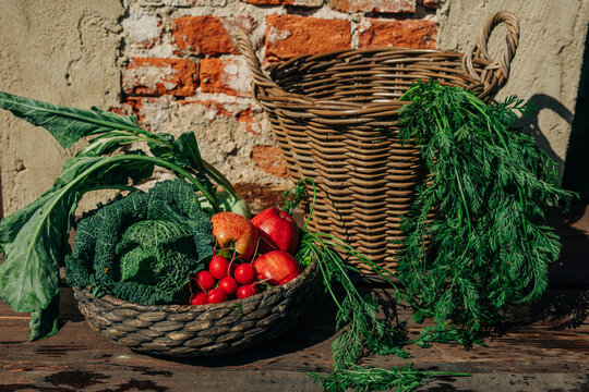 Fresh organic vegetables in vintage wicker basket on wooden table