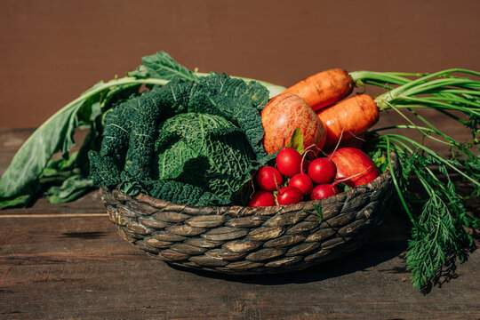Fresh organic vegetables and fruits in wicker basket on table