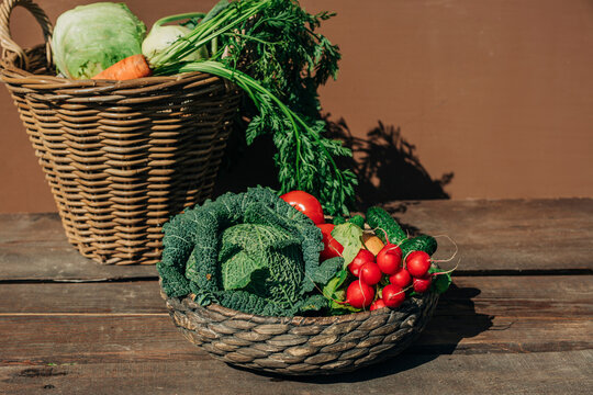 Organic vegetables in vintage wicker basket on wooden table