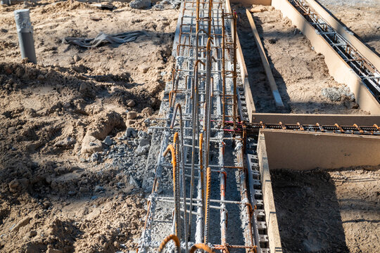 Canteiro de obras com a constru&ccedil;&atilde;o dos alicerces em bet&atilde;o e a arma&ccedil;&atilde;o de ferro para uma constru&ccedil;&atilde;o residencial