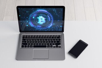 Close up of laptop with bitcoin on screen. White desk with smartphone. Crypto and money concept. 3D Rendering.