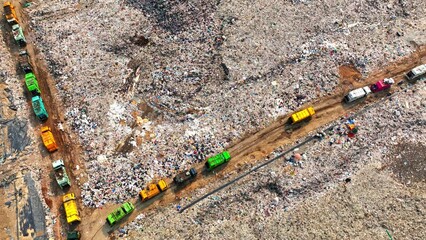 An aerial view unveils a litter-strewn landscape, punctuated by dirt trails and bustling garbage...