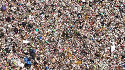A dense collection of mixed waste, with various colors and shapes indicative of a wide range of discarded materials. Garbage background. Aerial view.
