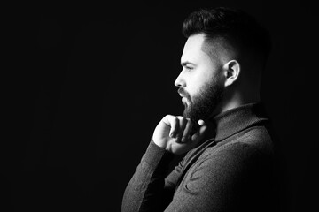 Portrait of handsome bearded man on dark background, space for text. Black and white effect