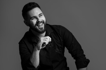 Portrait of handsome bearded man on grey background. Black and white effect