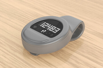 Grey clip-on fitness tracker on wooden desk 