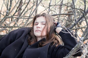 Tranquil woman resting in nature, peacefully lying on branches in forest. - 791434454