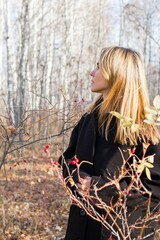 Pensive Woman in Stylish Black Coat Contemplating in Tranquil Autumn Woods, Serene Solitude. - 791435819