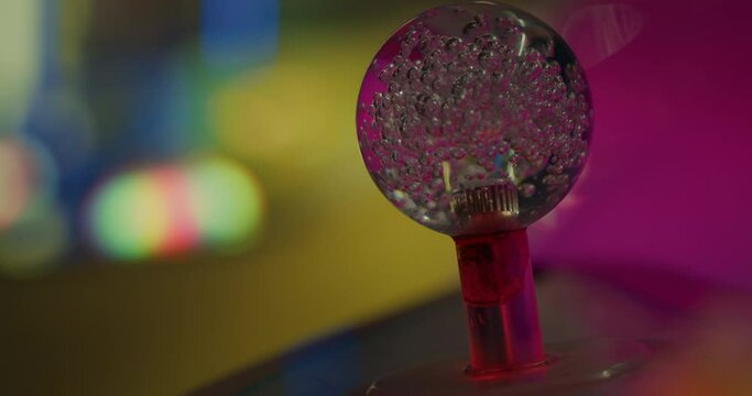 Detailed closeup of clear glass knob ball with bubbles and lights flickering from fair