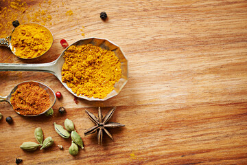 Spoons, spice and selection of powder for diet on kitchen table, turmeric and cardamom for art. Top...