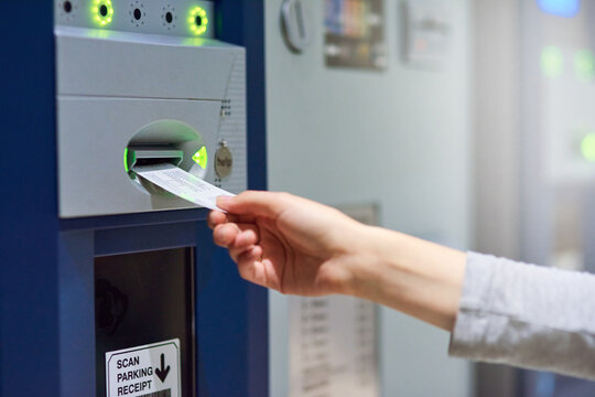 Parking lot, ticket and hand with meter machine for payment, cost and access for security, safety or garage space compliance. Exit, charge or driver with vehicle permit pass for toll, barrier or fees