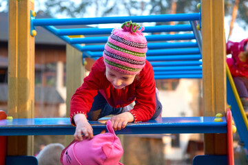 Cute child playing on the ladder at the playground