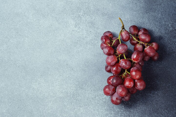 Vibrant Red Grape Bunch on Textured Grey Surface with Space for Text