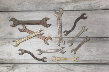 Different wrenches on a wooden background