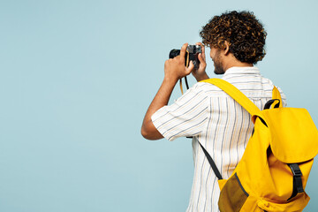Traveler Indian man wear white casual clothes bag use camera take photo picture isolated on plain blue background Tourist travel abroad in free spare time rest getaway Air flight trip journey concept - Powered by Adobe