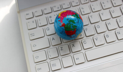 Earth Globe Model Lying On Computer Keypad With Latin Characters Only Top View 
