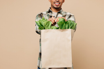 Close up cropped smiling fun young man wear grey shirt hold paper bag for takeaway mock up with...
