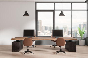 Modern coworking interior with pc computers on desks in row, panoramic window - 791452687