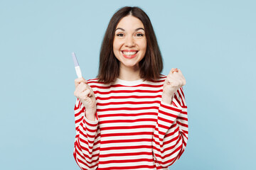 Young fun excited cool overjoyed happy woman wears red casual clothes hold in hand pregnancy test...