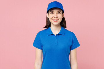 Professional smiling happy cheerful delivery girl employee woman wears blue cap t-shirt uniform workwear work as dealer courier look camera isolated on plain pastel pink background. Service concept.