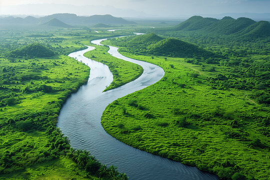 An aerial view of a winding river cutting through a lush green landscape