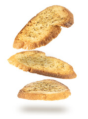 Falling slices of seasoned and crunchy bread, bruschetta style, isolated on white background.