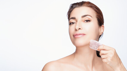 Elegant Woman Using Gua Sha Facial Tool for Skincare