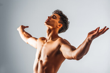 Dynamic portrait of shirtless male dancer posing with arms extended head tilted back against white studio background. Concept of human motions, wellness, natural beauty of male body.
