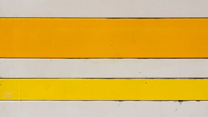 Rayas amarillas y blancas en pared de tablones de madera de quiosco