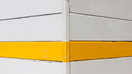 Rayas amarillas y blancas en pared de tablones de madera de quiosco